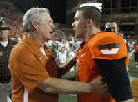 Texas coach Mack Brown, left, talks with Oklahoma State quarterback J.W. Walsh following the Longhorns’ win Saturday in Stillwater, Okla.AP/Sue Ogrocki