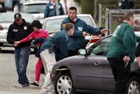 A neighbor is escorted to safety as police surround a home while searching for a suspect in the Boston Marathon bombings in Watertown, Mass., Friday, April 19, 2013. The two suspects in the Boston Marathon bombing killed an MIT police officer and hurled explosives at police in a car chase and gun battle overnight that left one of them dead and his brother on the loose, authorities said Friday.Charles Krupa - AP