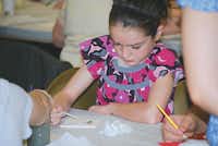 Joy Bender paints a wall tile during Sunday school service in the church's fellowship hall.John D. Harden - DRC