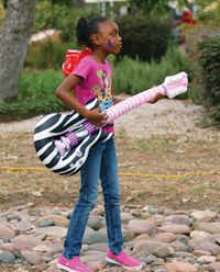 Eightyear-old Kyaisha Milton rocks out with her inflatable guitar.David Minton/DRC