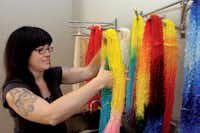 Lindsay Lee, an assistant at Dragonfly’s Hollow, dyes yarn into bright colors from a neutral base color on Monday at the shop in DentonAl Key/DRC