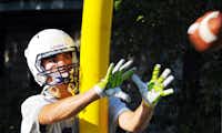 Denton High's Pearson Schroll practices catching passes with the goal post in the way on the first day of football practice Monday morning.Barron Ludlum - Chronicle