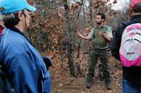 Park Ranger Rick Torres tells New Year’s Day hikers about the types of minerals that can be found on branches, helping lead to the growth of fungi and mushrooms, on Sunday at the Isle du Bois Unit of Ray Roberts Lake State Park, near Pilot Point.Tomas Gonzalez - DRC