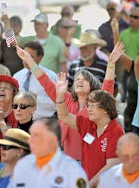 Jane Torrie raises her arms in praise as the Rev. Bruce Troy of Southmont Baptist Church says a prayer Thursday for the U.S. armed forces and veterans during the National Day of Prayer on the lawn of the Courthouse on the Square in Denton.Al Key