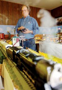 Steve Davis operates the controls of his model train exhibit Monday at his business, The Wood House, in Denton.Al Key - DRC