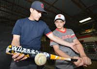 Jared McClure, left, helps 13-year-old Joshua Hunter with the mechanics of his swing recently in Denton.Al Key