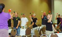 Tenor drum instructor Allie Guerrero teaches flourishing (spinning tenor mallets) to firemen at the Pipes and Drums Conference hosted by the Lewisville Fire Department at the Hilton Garden Inn in Lewisville Thursday May 9, 2013. Photo by Al Key/DRCAl Key