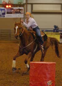 Callie Barrett, 17, of Pilot Point rounds the barrel with her horse Champ on Monday during the Denton County Livestock Association horse competition at Diamond T Arena in Denton.Al Key - DRC
