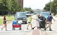Anjelika Cortez, left, an incoming freshman at Texas Woman’s University, gets help moving into the dorm from her mom Annette, second from left, her brother Joey, second from right, and her father Hernan, right, as they cross Bell Avenue to go to Stark Hall on Wednesda.Al Key