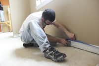 A volunteer finishes baseboard work in the renovated facility designed to house nonprofit agencies providing assistance to those in need.