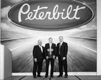 Eddy Stahl, center, dealer principal and president of Stahl Peterbilt-Edmonton, accepts the dealer of the year award from Robert Woodall, left, Peterbilt director of sales and marketing, and Bill Kozek, Peterbilt general manager and PACCAR vice president.