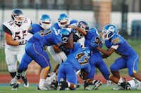 Ryan senior running back Tyrone Williams (6) is brought down by a pack of Corsicana defenders, Friday, August 30, 2013, at Tiger Stadium in Corsicana.David Minton