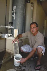 In June, Damon Smith shows the dirty water filter he changed just five days ago at his home in Dish. Smith said his wife, Amber, first noticed the water’s gray appearance in March 2009 after a gas well was drilled near the family's home. Early testing of the Smiths’ well water found levels of arsenic, lead and chromium unsafe to drink. Subsequent tests found lower levels of contamination.