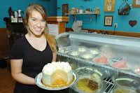 Sidewalk Cafe server Catherine Harrington holds a vanilla cake, one of the many desserts provided by Poppyseed Baking Co., locally owned by Deanie Willis and Amy Griffin.Al Key - DRC